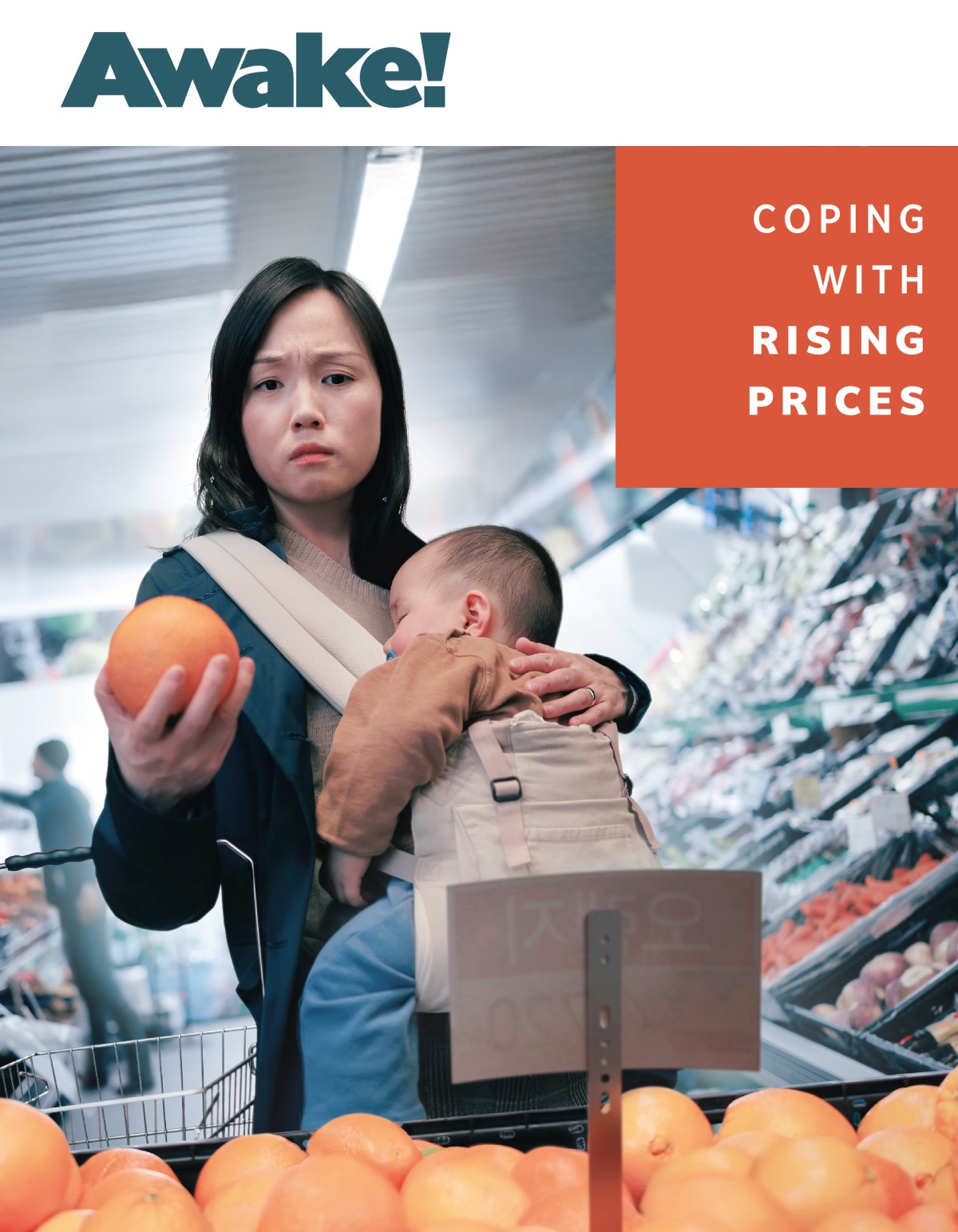 A mother anxiously looking at the price of some fruit while she grocery shops with her sleeping baby.