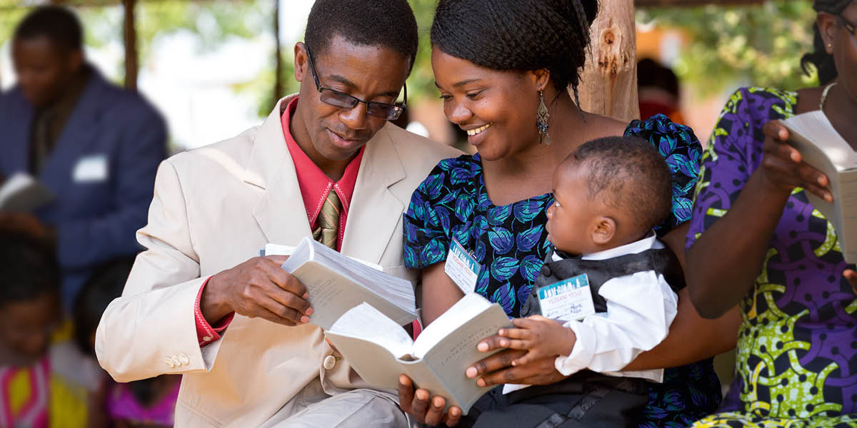 A family holding personal copies of the ‘New World Translation’ after its release in their language.