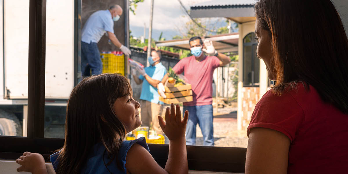 Brothers delivering relief supplies to a mother and her young daughter.