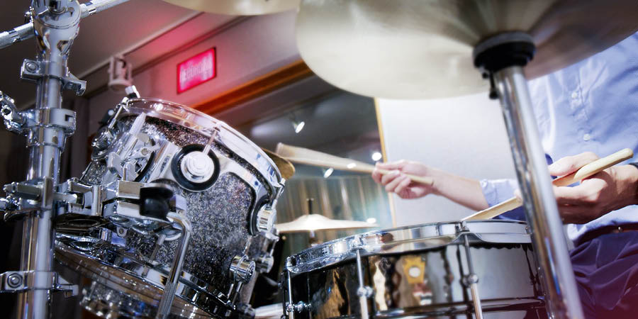A brother playing the drums during a recording session.