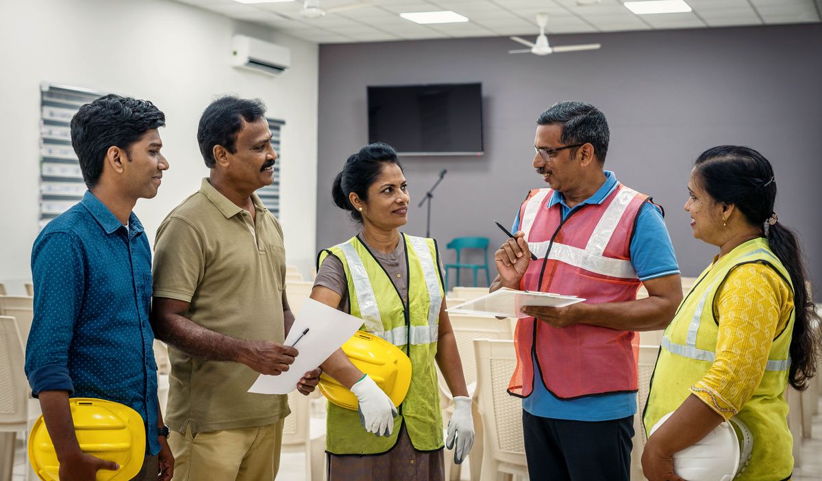 A maintenance trainer talking with brothers and sisters at a Kingdom Hall.