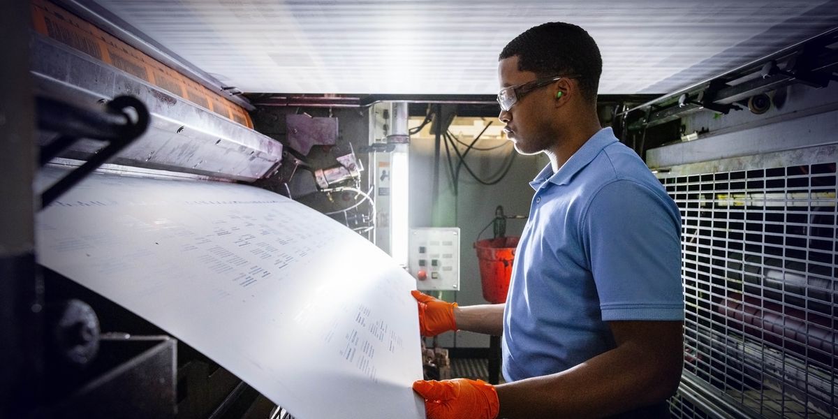 A brother changing a plate on a printing press.