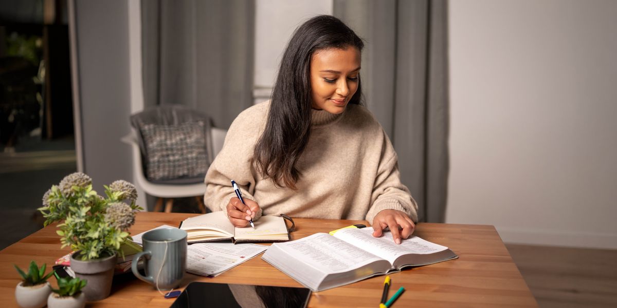 A sister studying printed editions of the Bible and the “Life and Ministry Meeting Workbook.”