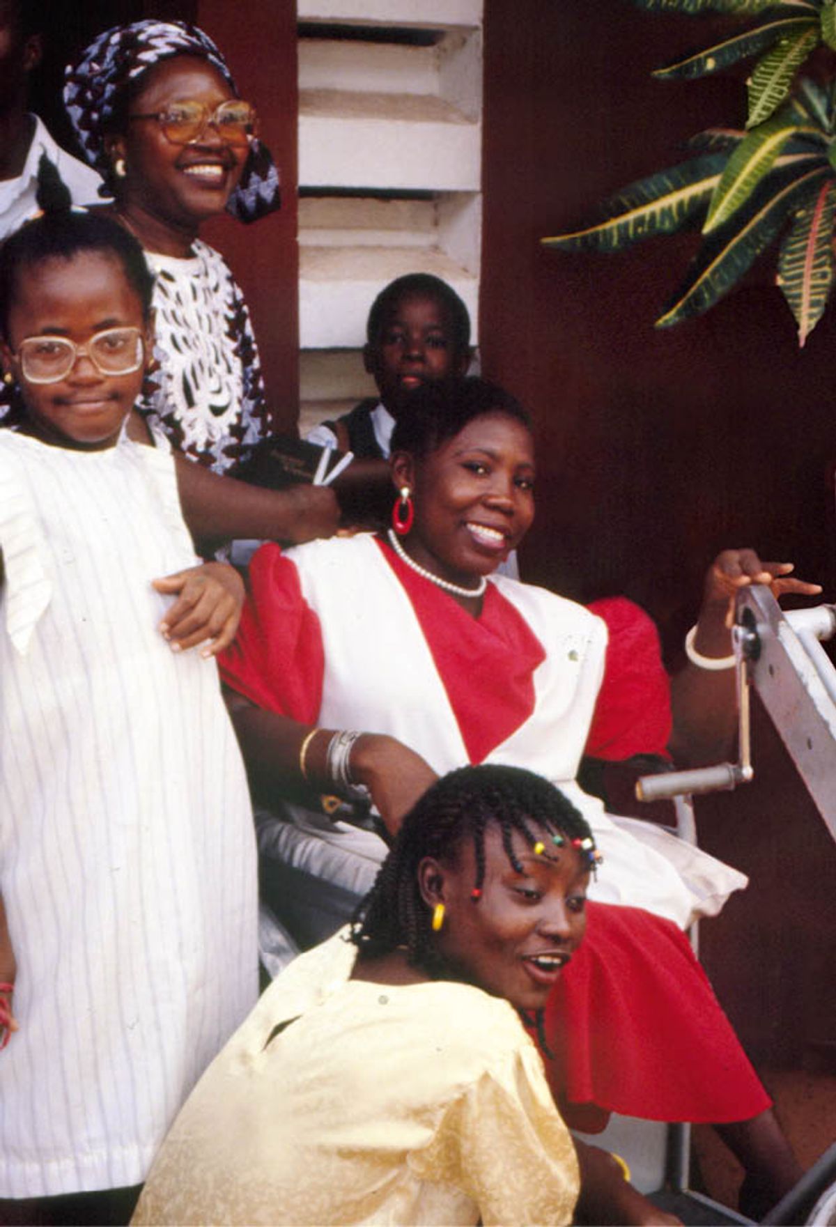 Jay happily sitting in her wheelchair, surrounded by some of her friends.