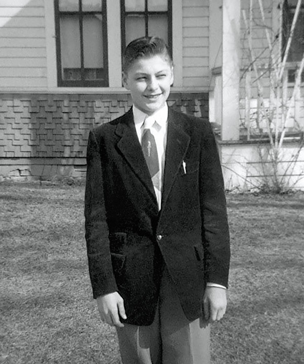Young Karl smiling while dressed in a jacket and tie.