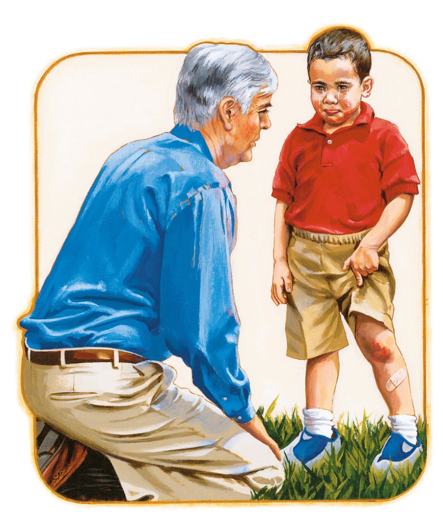 A man comforts a boy who has skinned his knee