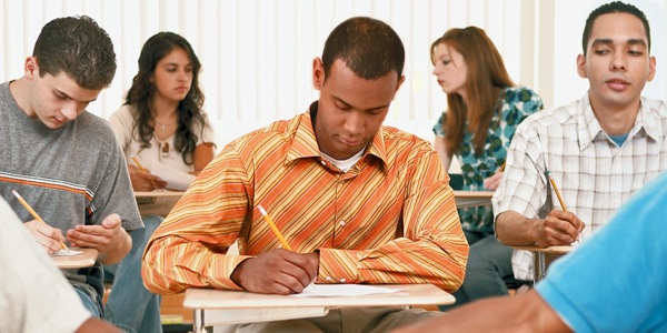 A student stays honest during a written test while others around him cheat