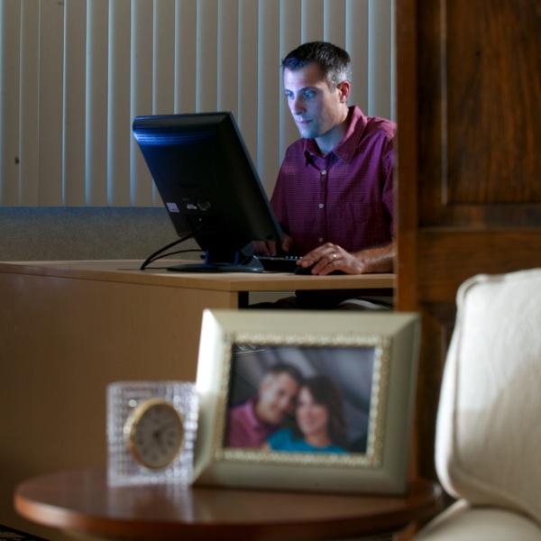 A married man using a computer to browse the Internet late at night