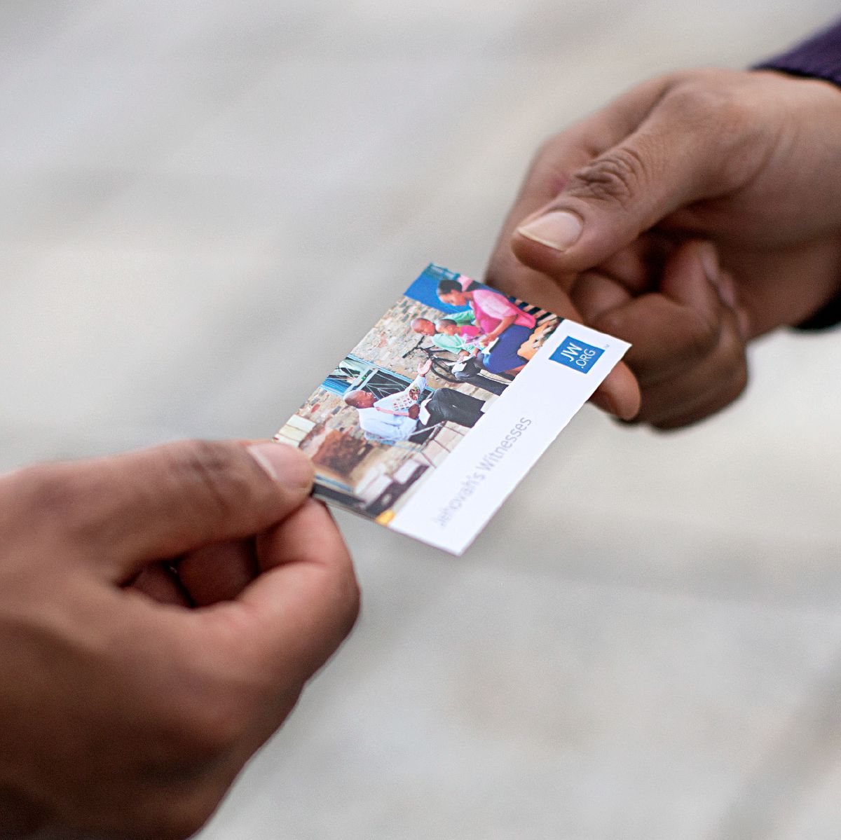 One of Jehovah’s Witnesses gives a person a jw.org contact card