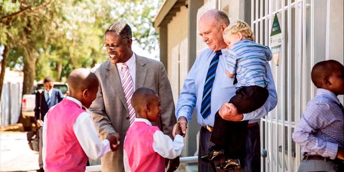 Johny and Gideon welcome children to the Kingdom Hall