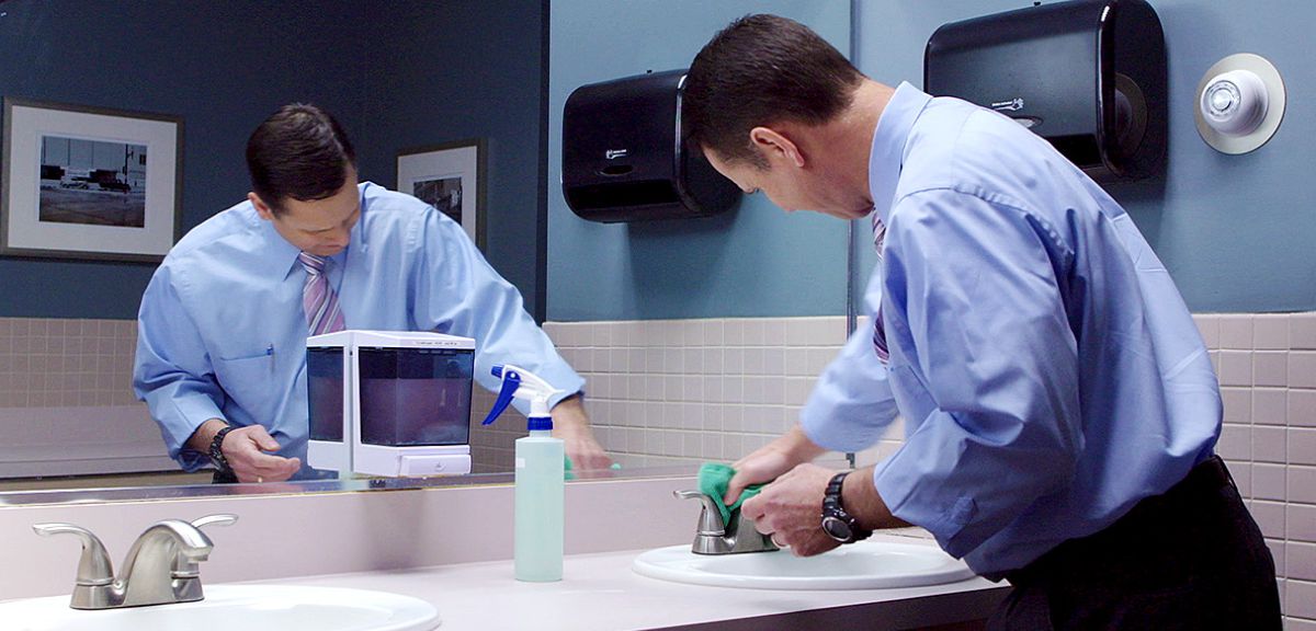 A brother cleans the bathroom at a Kingdom Hall