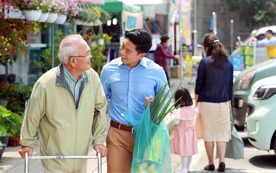 A younger brother helps an older brother with shopping