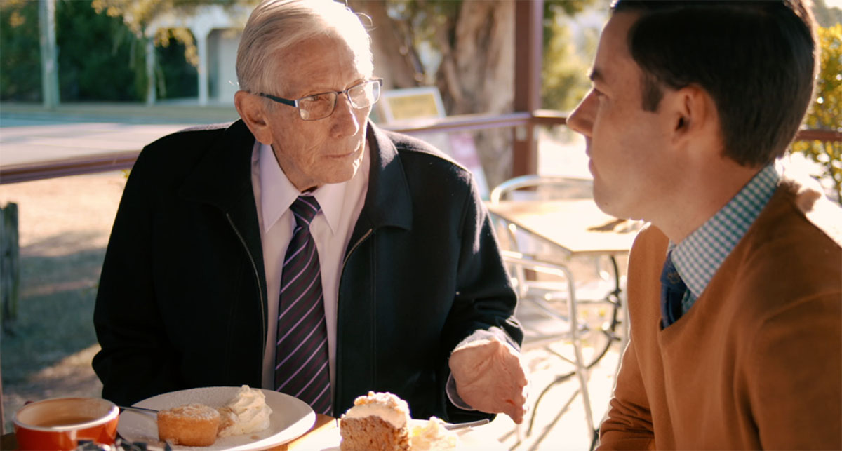 Brother Bello talks with Ben as they enjoy refreshments together