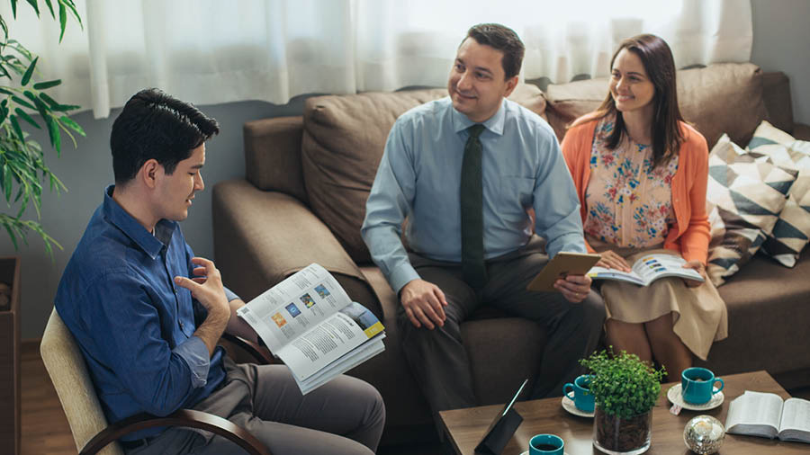 The same couple using the “Enjoy Life Forever!” book to conduct a Bible study with the man at his home.
