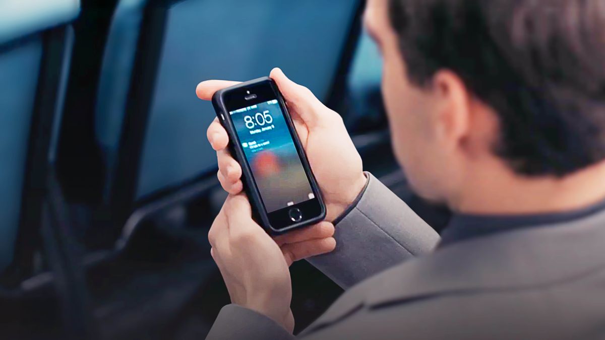 A scene from the video “God ‘Is Aware of the Secrets of the Heart.’” The brother receiving a text message during the meeting.