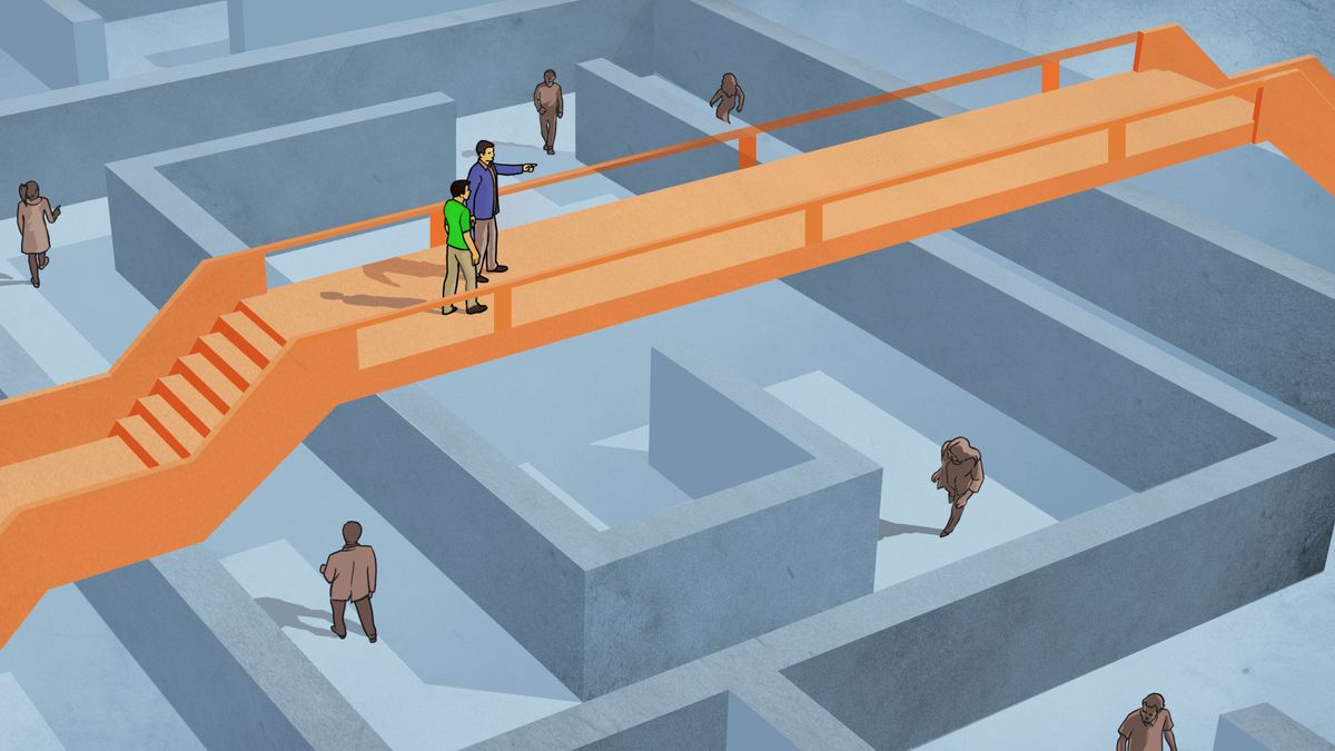 A man being led by another man across a bridge that spans a labyrinth. Other people below the bridge wander inside the labyrinth.