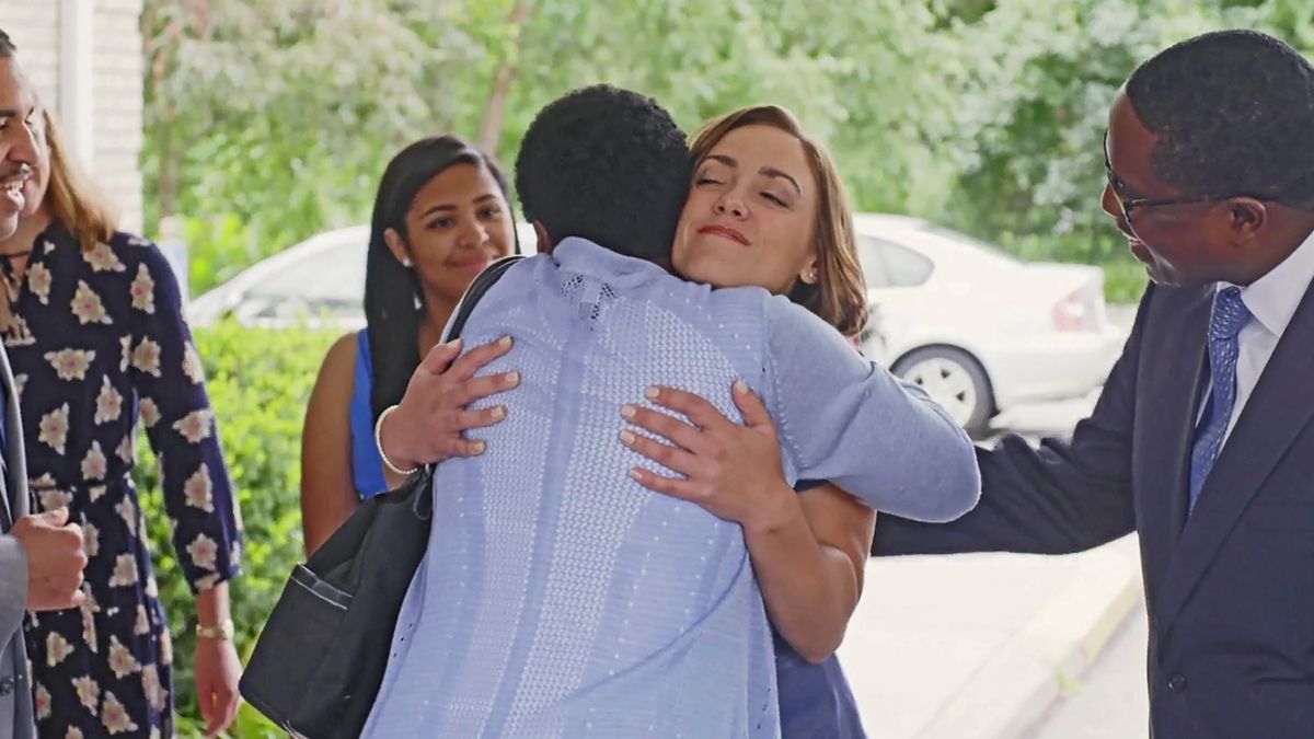 A scene from the video “I Turned My Life Around.” The sister from the video receives a warm welcome from brothers and sisters at the entrance of a Kingdom Hall.