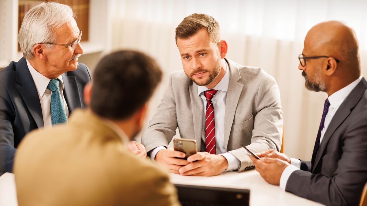 Three elders meeting with a brother. The brother listens attentively while the elders speak to him.
