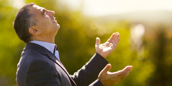 A man looking up toward heaven with his hands open to God