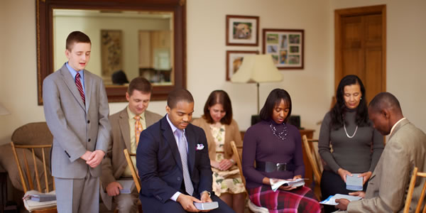 A young man representing a group of Jehovah’s Witnesses in prayer