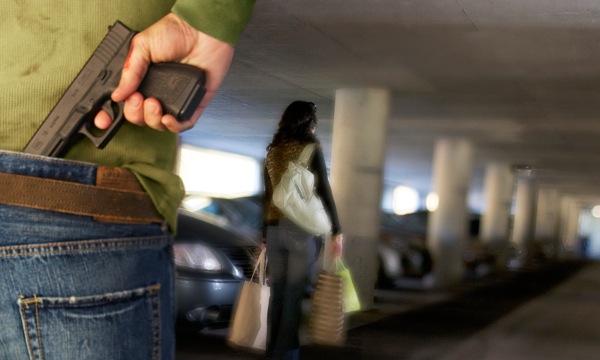 A woman in a parking lot about to become a victim of crime