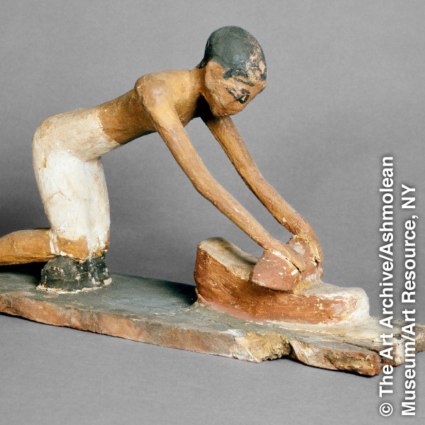 Egyptian artifact of a person grinding on a hand mill