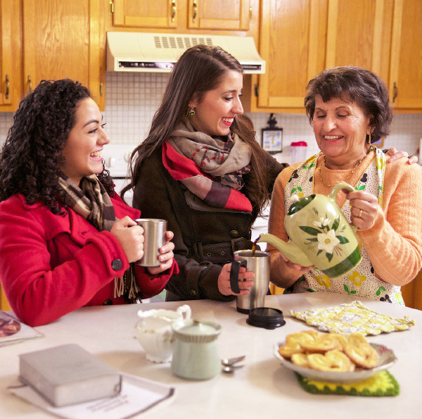 An older sister shares refreshments with younger ones