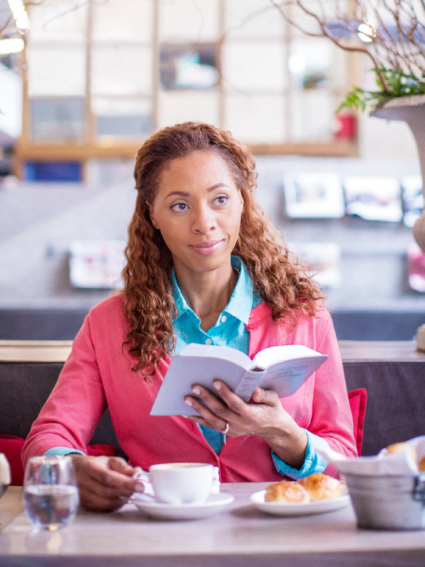 A woman holds her Bible open and confidently gazes ahead