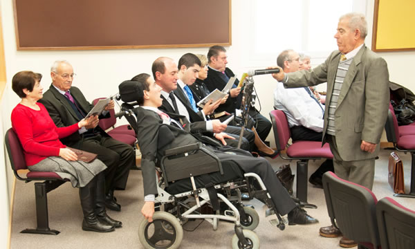 Jairo using his computer to make a comment at a meeting
