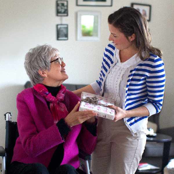 An older woman giving a gift to a friend