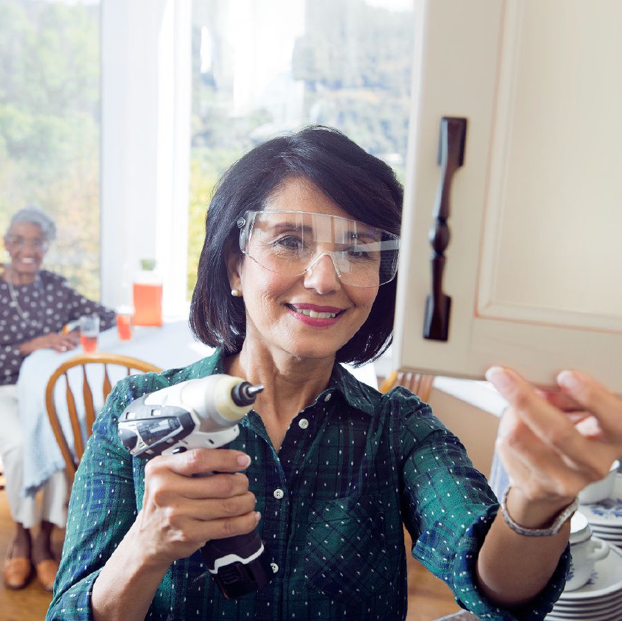 A sister makes a repair in an elderly sister’s home