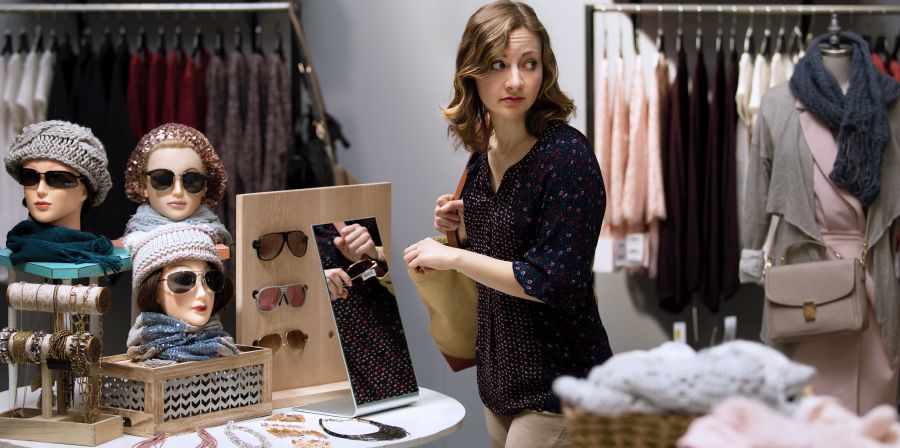 A woman steals sunglasses in a shop
