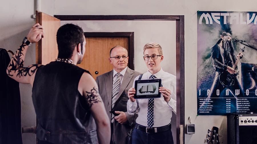 A brother in the field ministry shows a man, who is tattooed and wearing heavy jewelry, the video Why Study the Bible?