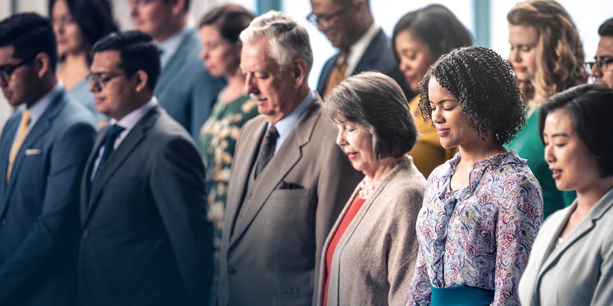 Brothers and sisters in a congregation bow their heads for a prayer
