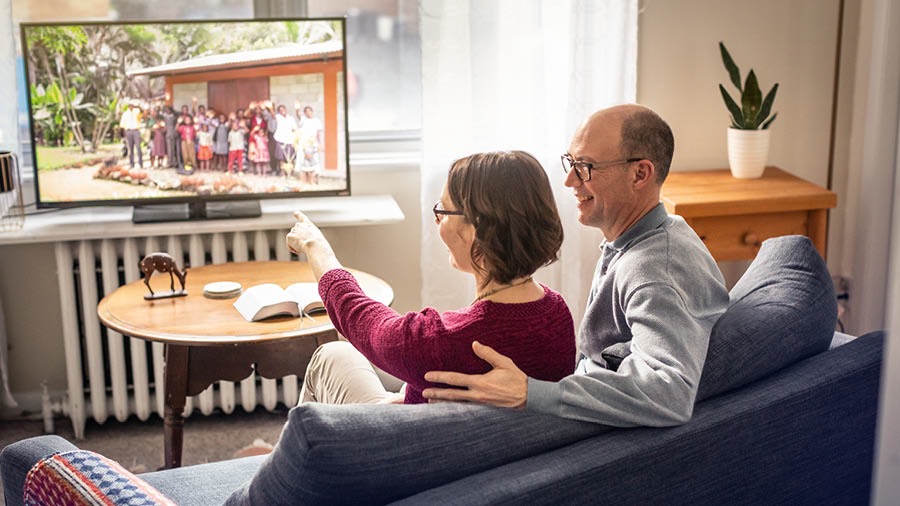 A former missionary couple enjoy watching a video of friends in their previous congregation
