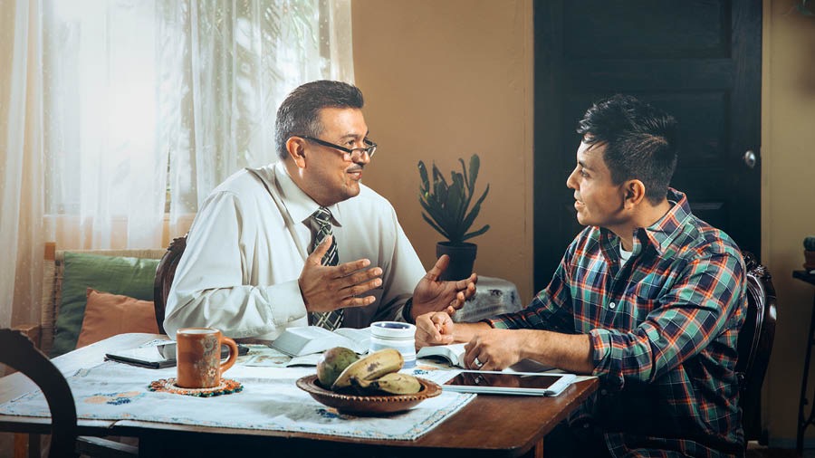 A brother conducting a Bible study with a man at his home.