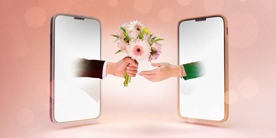 Two mobile devices with their screens facing each other. A man’s hand extends out of one screen with a bouquet of flowers, and out of the other screen, a woman’s hand reaches to accept them.