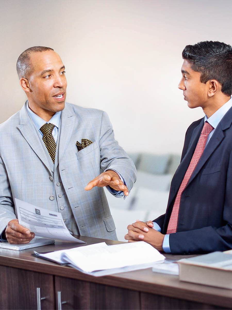 An elder training a young brother for a congregation assignment.