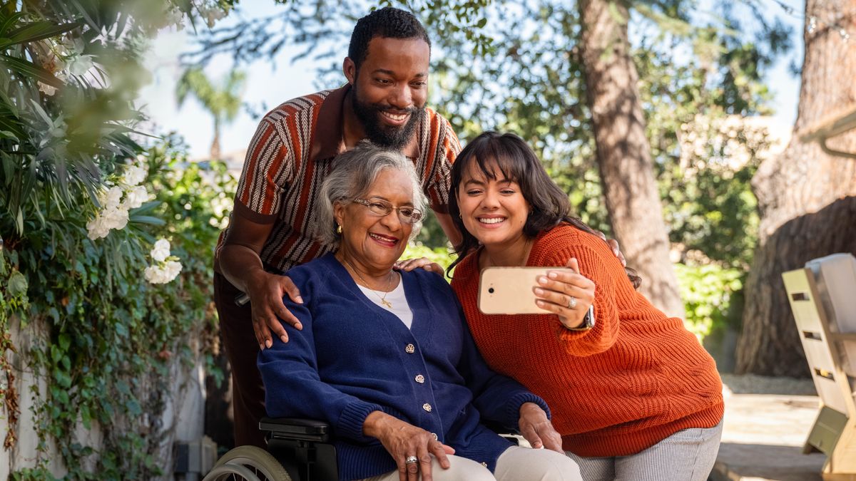 The sister from the previous images, taking a selfie with her unbelieving husband and her mother-in-law, who is sitting in a wheelchair.