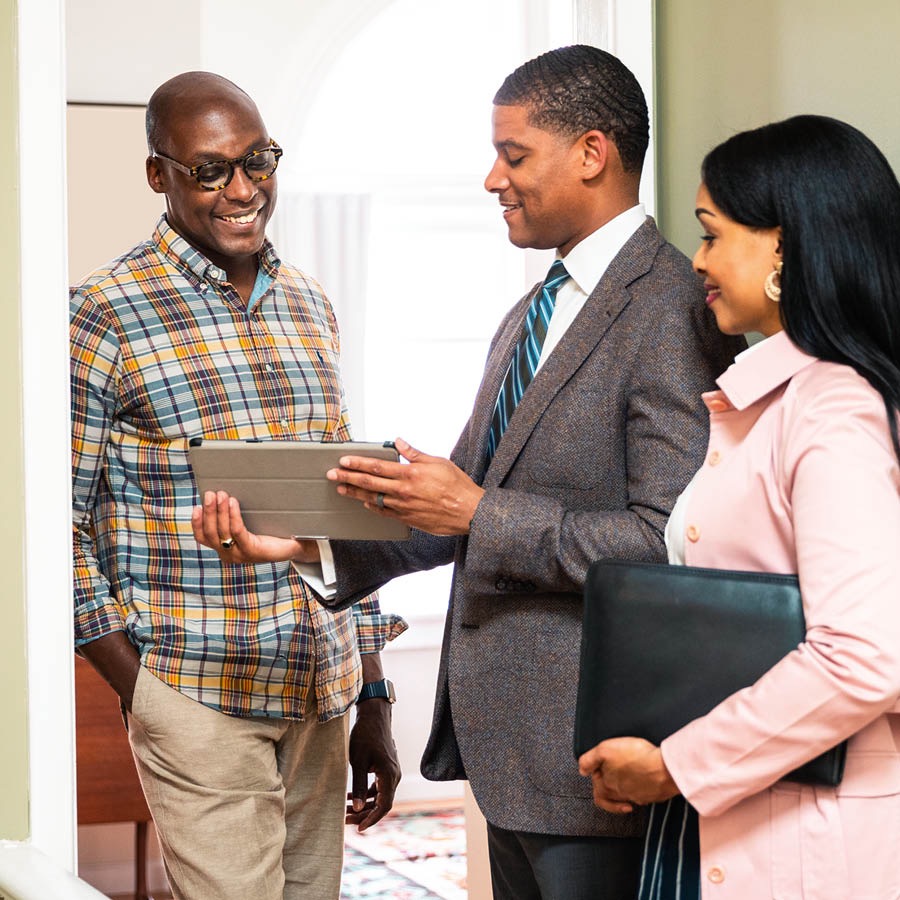 Jehovah’s Witnesses talking to a man at the door of his home.