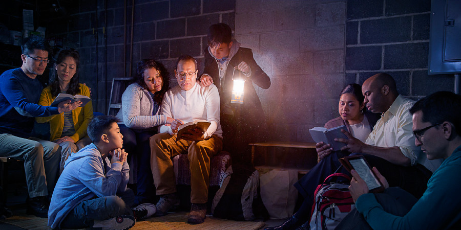 In an area where their work is restricted, Jehovah’s Witnesses hold a meeting in a dark basement