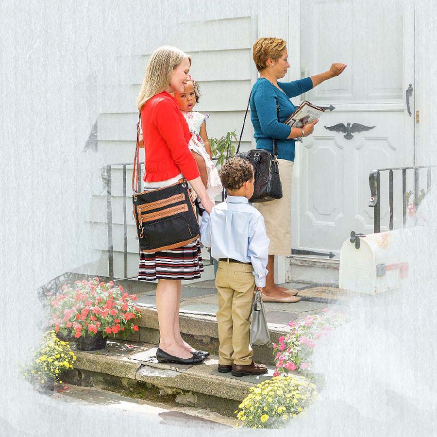 A sister helps another sister with her two little children in the field ministry