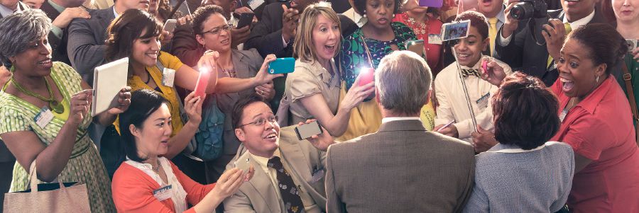 A Christian brother and his wife surrounded by a crowd of people taking pictures of them