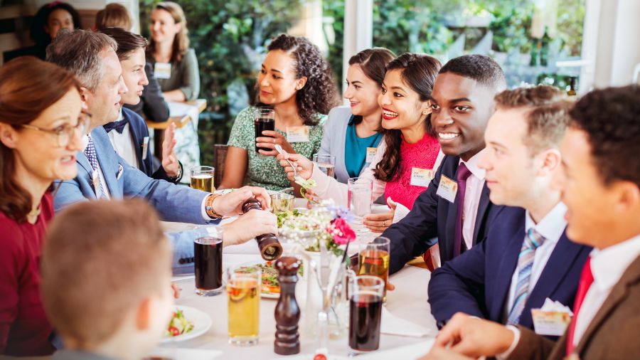 Young people of various races enjoy a meal together after a convention