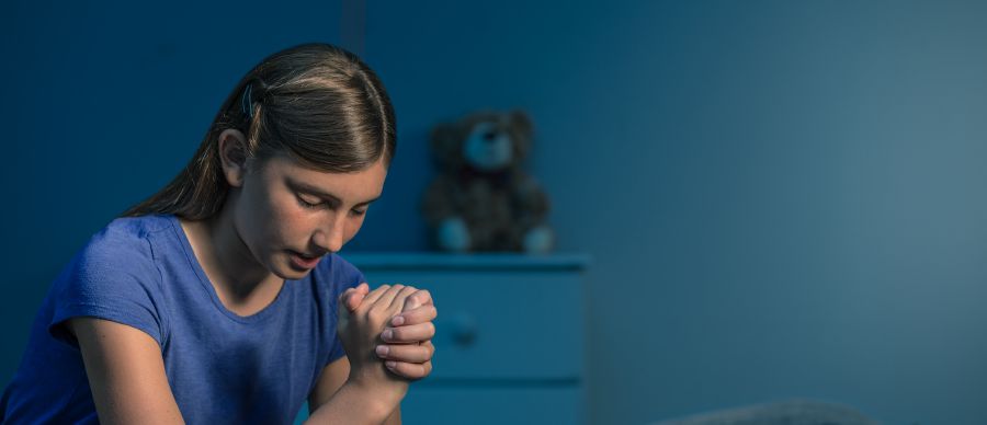 A girl makes her dedication in prayer
