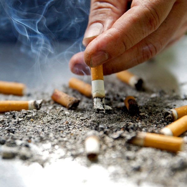 Una persona apagando un cigarrillo