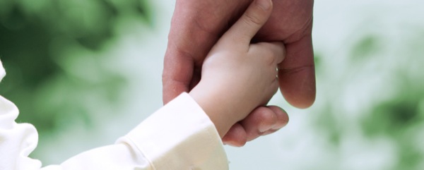 La mano de un padre tomando la de su hijo