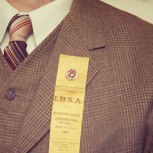 Un hombre con su insignia de una cruz y una corona en la solapa de su traje