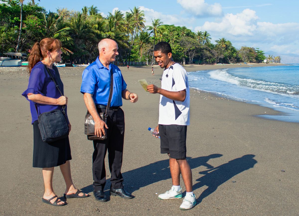 En la playa, Warren y Leann le predican a un hombre.