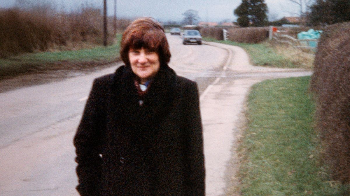 Junto a una carretera, Carol sonríe.